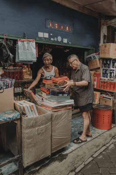 男人穿着棕色礼服衬衫搬着箱子

